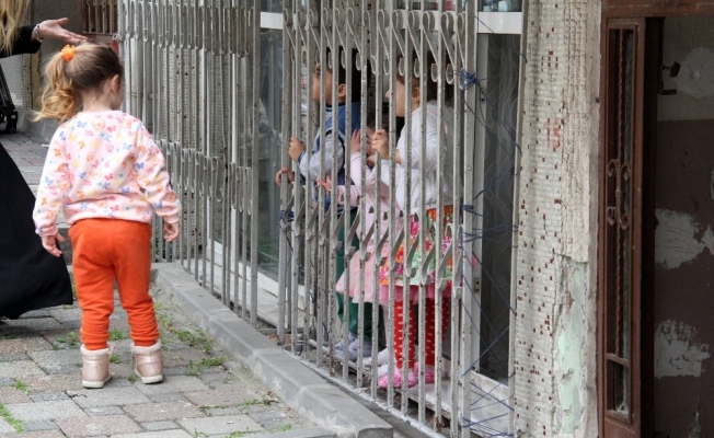 Virüsten korkan küçük kız yaşıtlarını camdan izledi